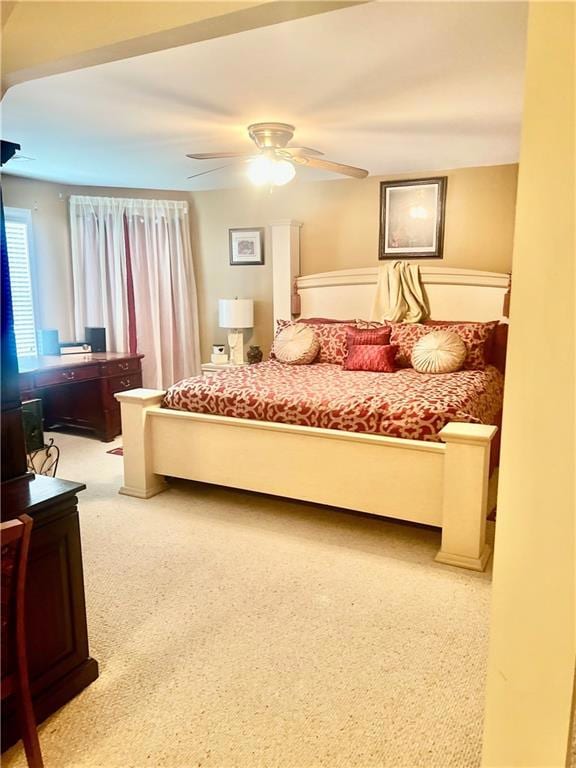 Carpeted bedroom with ceiling fan and a desk
