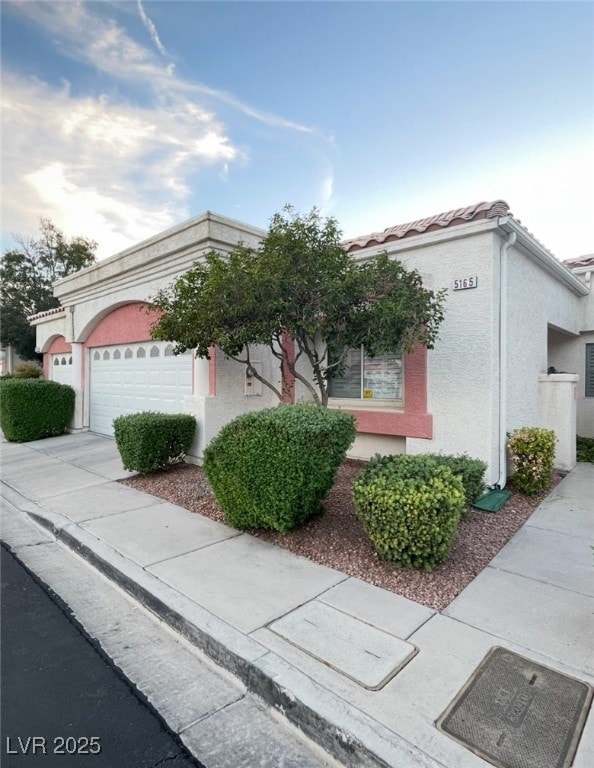 View of front of home with a garage, stucco siding