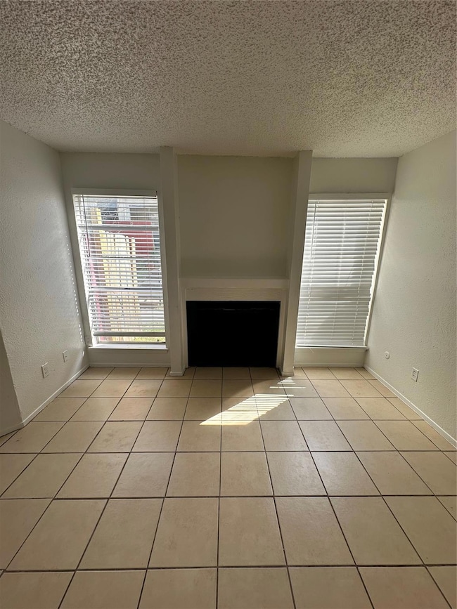 Unfurnished living room with a fireplace, light ti