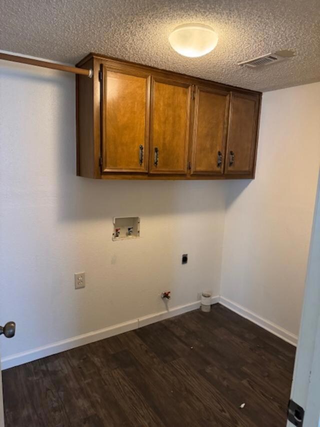 Clothes washing area with dark wood-style floorin