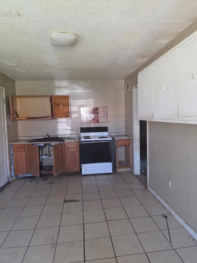 Kitchen featuring light tile patterned floors, ele
