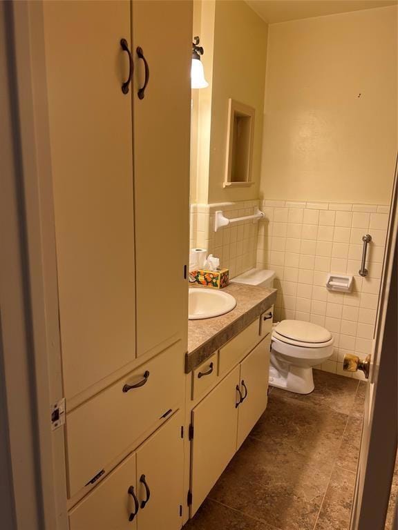 Bathroom with vanity, a wainscoted wall, and tile