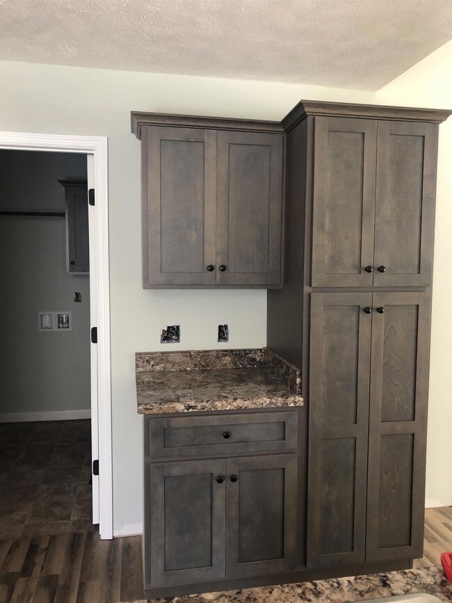 Kitchen cabinets to the right of laundry room. 