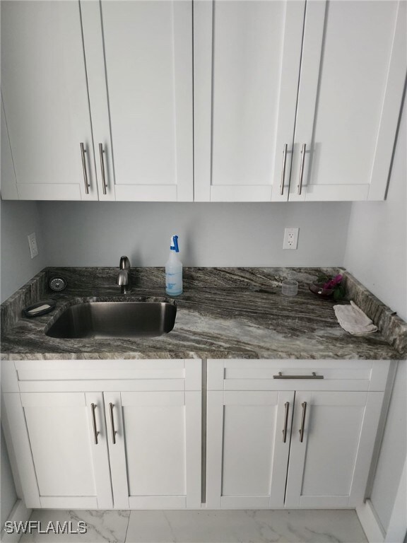 Kitchen featuring light marble finish flooring, wh