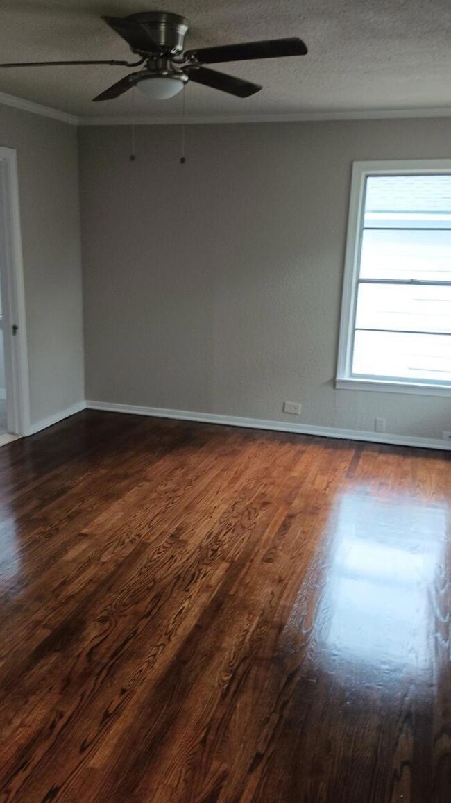 Empty room with ceiling fan, hardwood / wood-style