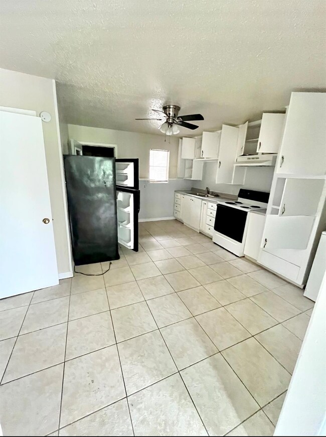 Kitchen with white cabinets, electric range, ceili