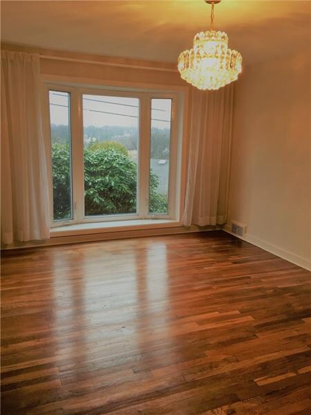 Dining room with a bay window and hardwood floor.