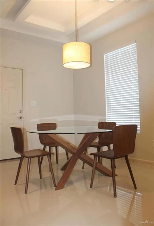 Dining area featuring a tray ceiling and baseboards