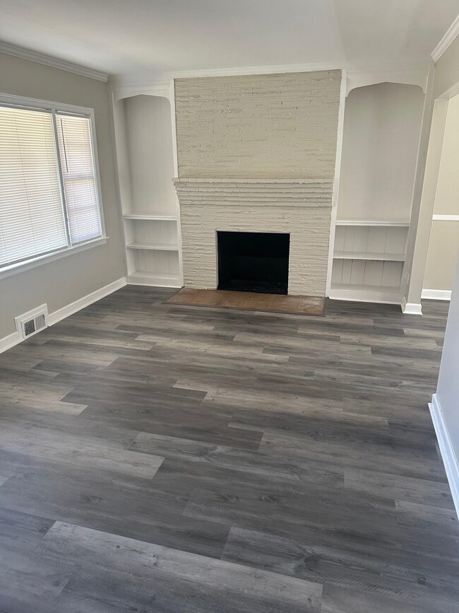 Unfurnished living room featuring dark wood-style 