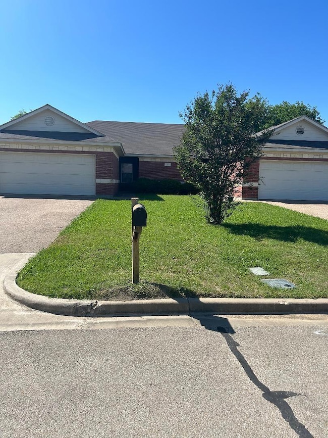 Ranch-style house with brick siding, an attached g