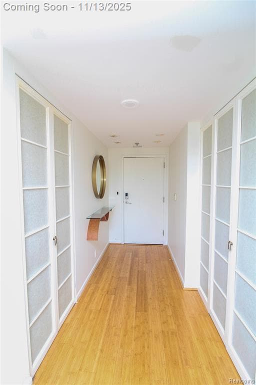 Corridor featuring light wood-style floors and baseboards