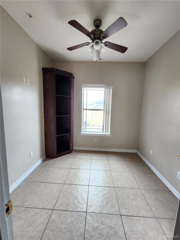 Tiled empty room featuring ceiling fan