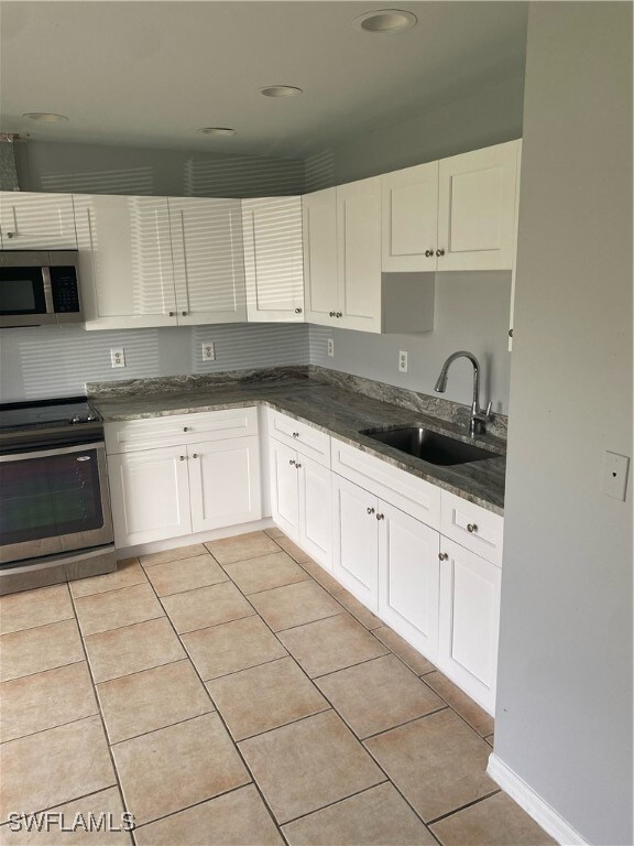 Kitchen featuring range, light tile patterned floo