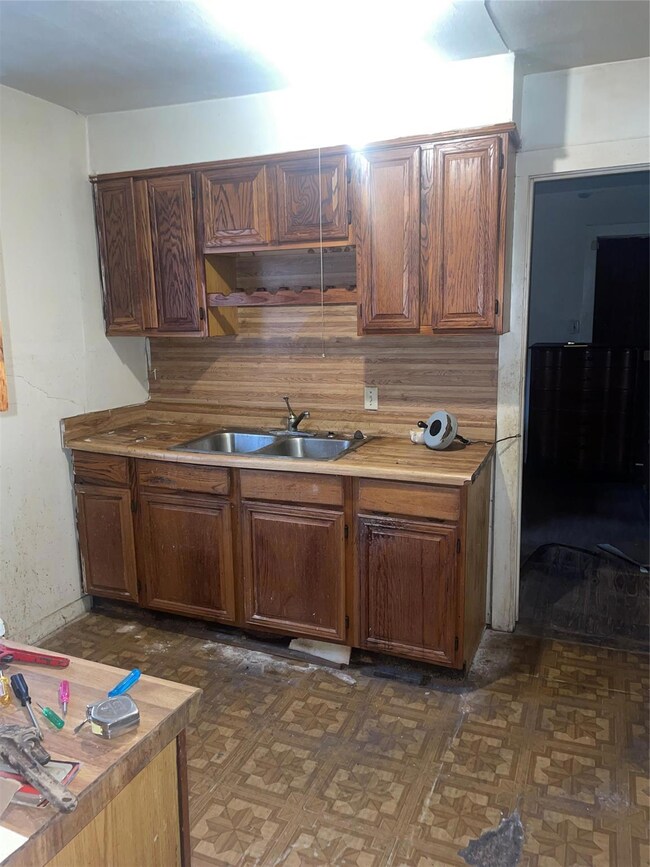 Kitchen with backsplash, sink, and dark parquet fl