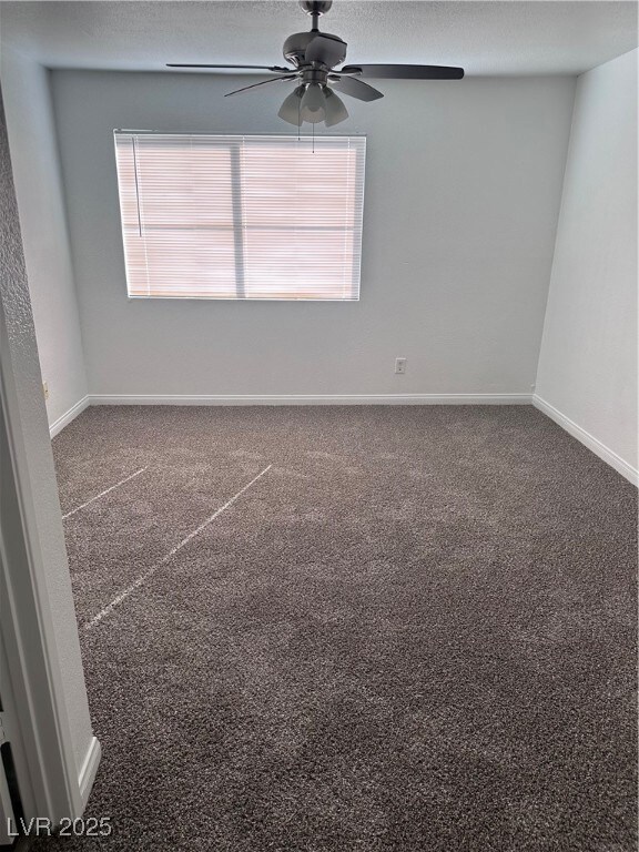 Empty room featuring carpet flooring, ceiling fan,