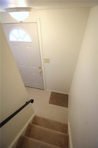 Ceramic tile entryway with updated front door.