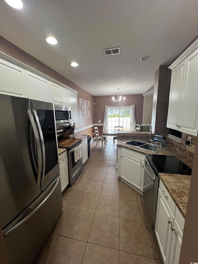 Kitchen with stainless steel appliances, hanging l