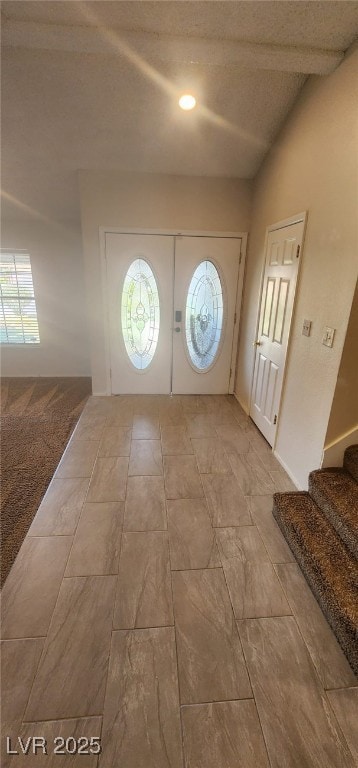 Entrance foyer with stairs, a textured ceiling, an