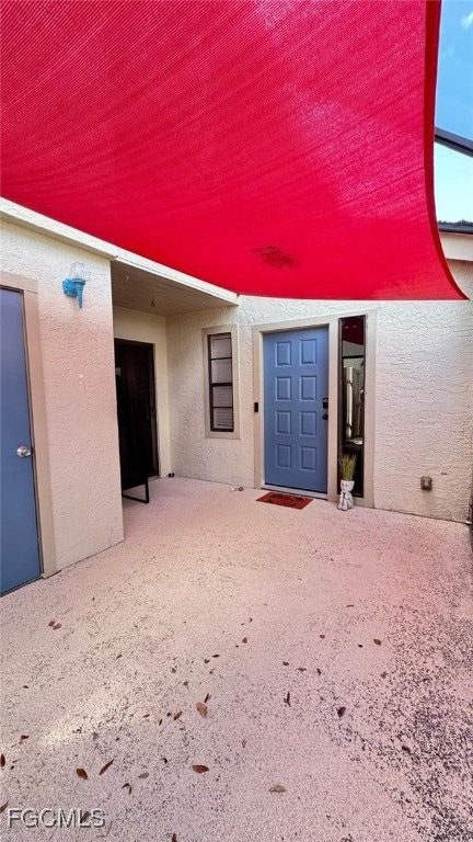 Entrance to property featuring stucco siding