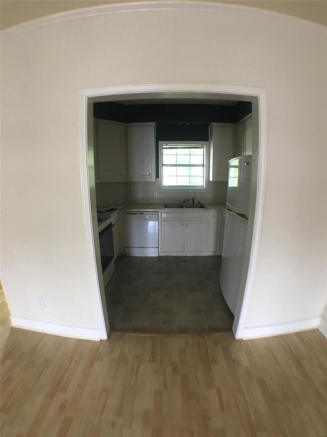 Kitchen with white cabinets, a sink, baseboards, 