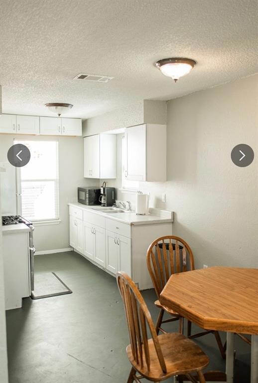 Kitchen with a textured ceiling, concrete floorin