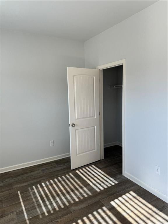 Unfurnished bedroom with dark hardwood / wood-styl