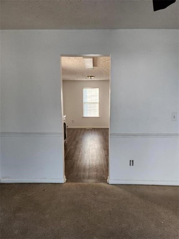 Empty room featuring carpet and a textured ceiling