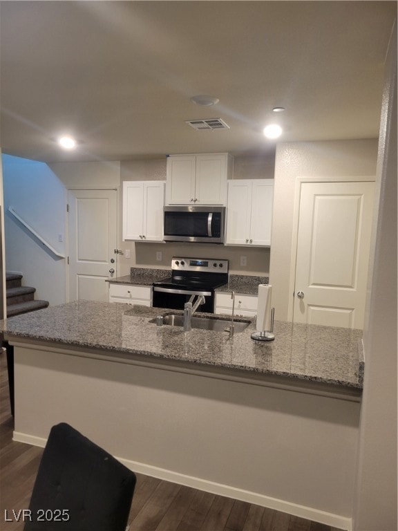 Kitchen featuring stove, a sink, stone countertops