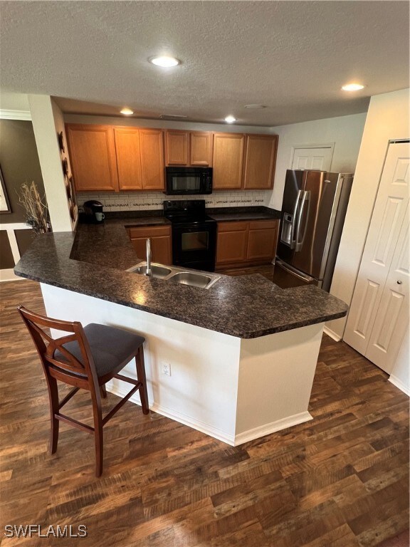 Kitchen with range, refrigerator, a peninsula, dar