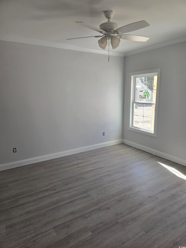 Unfurnished room with ceiling fan, dark hardwood /