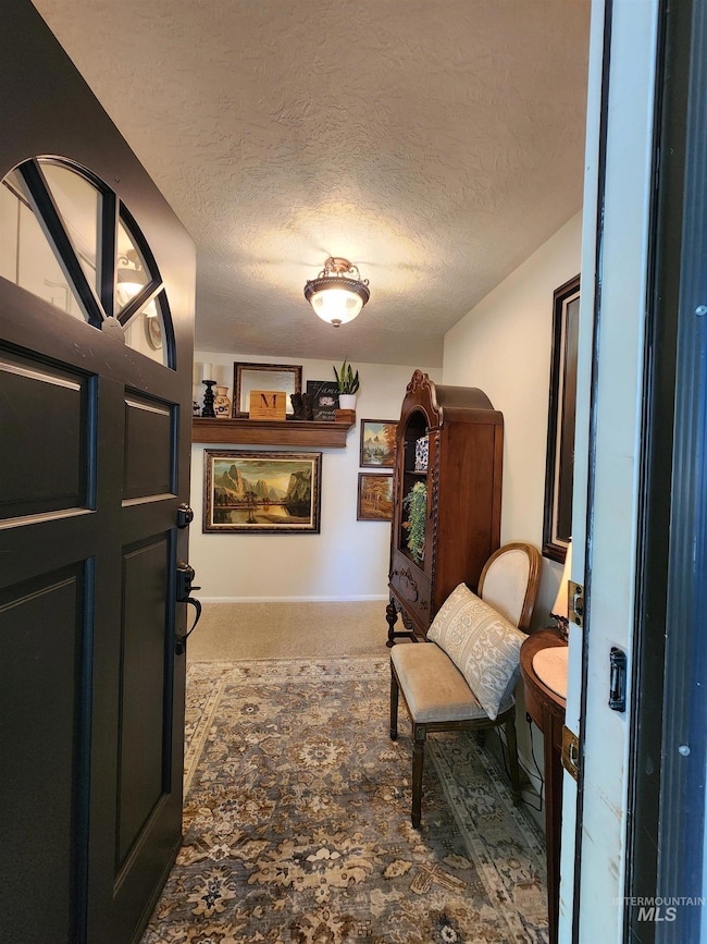 Sitting room featuring a textured ceiling and light carpet