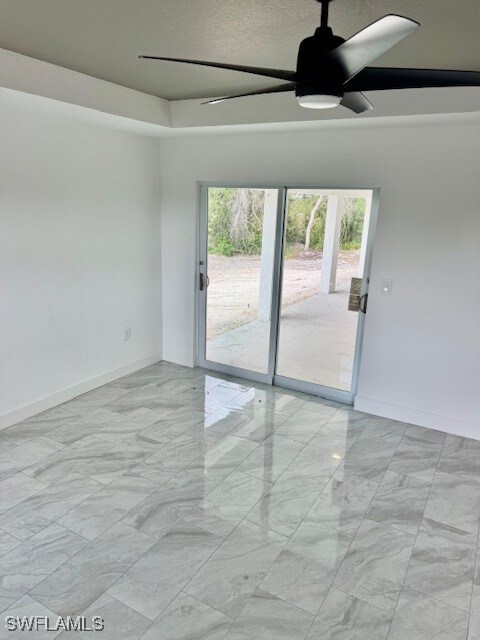 Spare room featuring ceiling fan, light marble fin