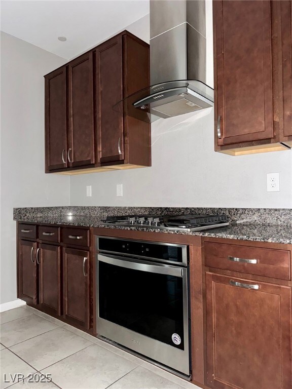 Kitchen featuring wall chimney exhaust hood, light