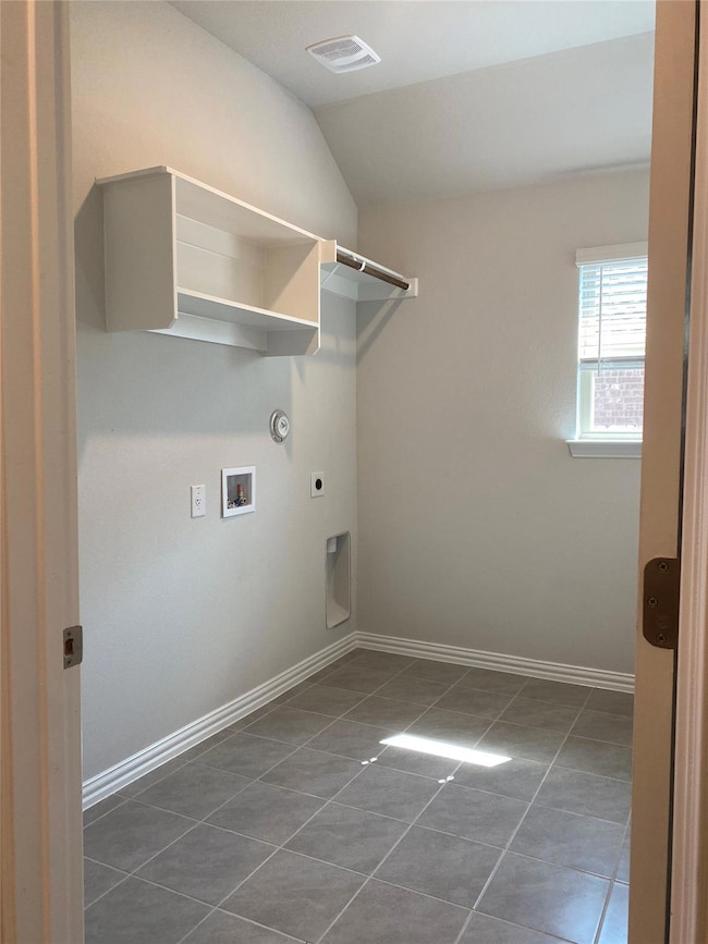 Washroom with dark tile patterned floors, laundry