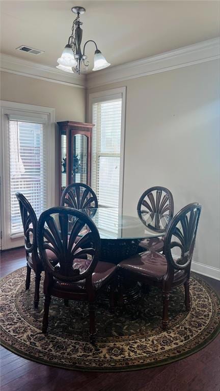 Dining room featuring a wealth of natural light, a chandelier, ornamental molding, and hardwood / wood-style floors