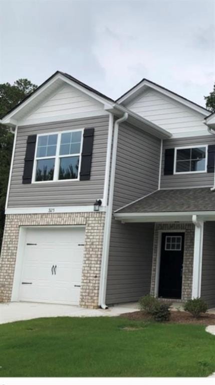 View of front of property featuring brick siding, a front yard, and an attached garage