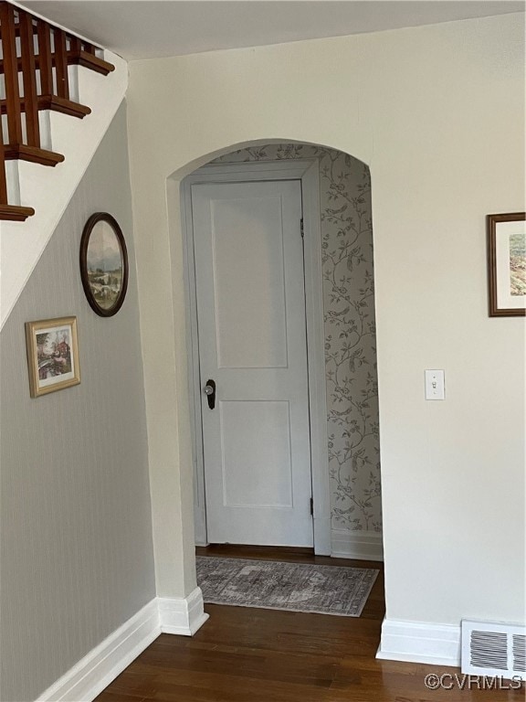 Corridor featuring wallpapered walls, dark wood-ty