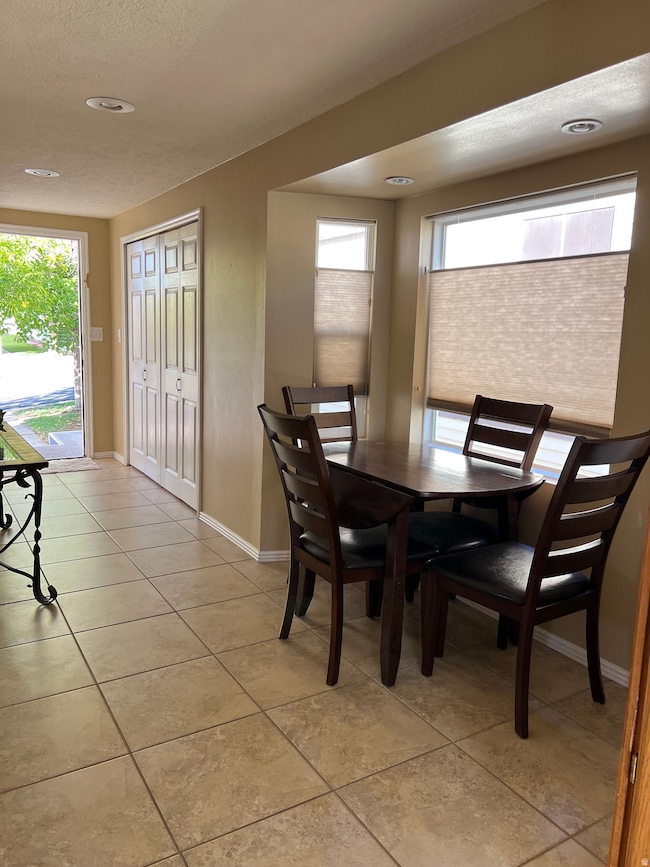 Dining area with a textured ceiling and light tile patterned floors