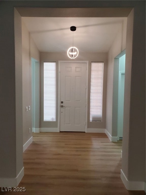 Entryway with baseboards, wood finished floors, an