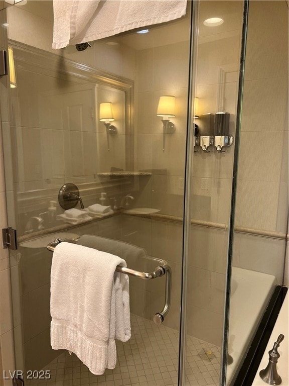 Bathroom featuring a stall shower and tile walls
