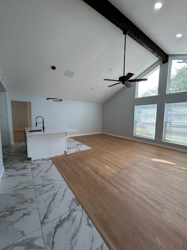 Unfurnished living room featuring ceiling fan, li