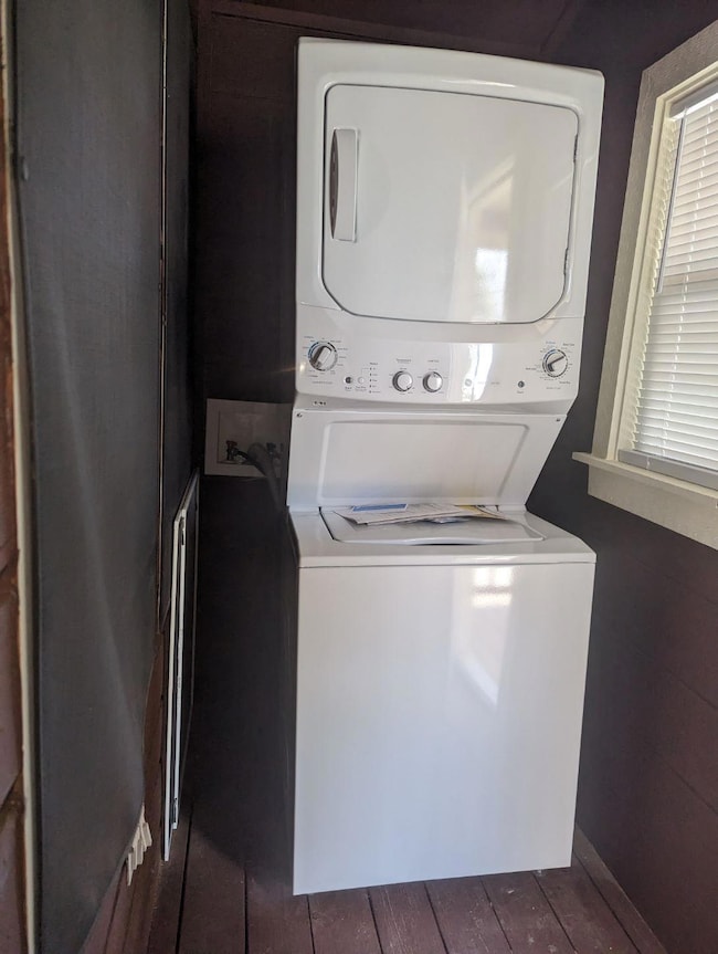 Clothes washing area featuring dark wood-style fl