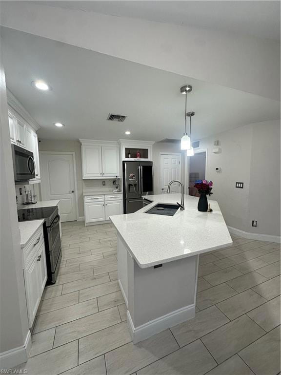 Kitchen featuring refrigerator with ice dispenser, sink, stove, white cabinetry, and a kitchen island with sink