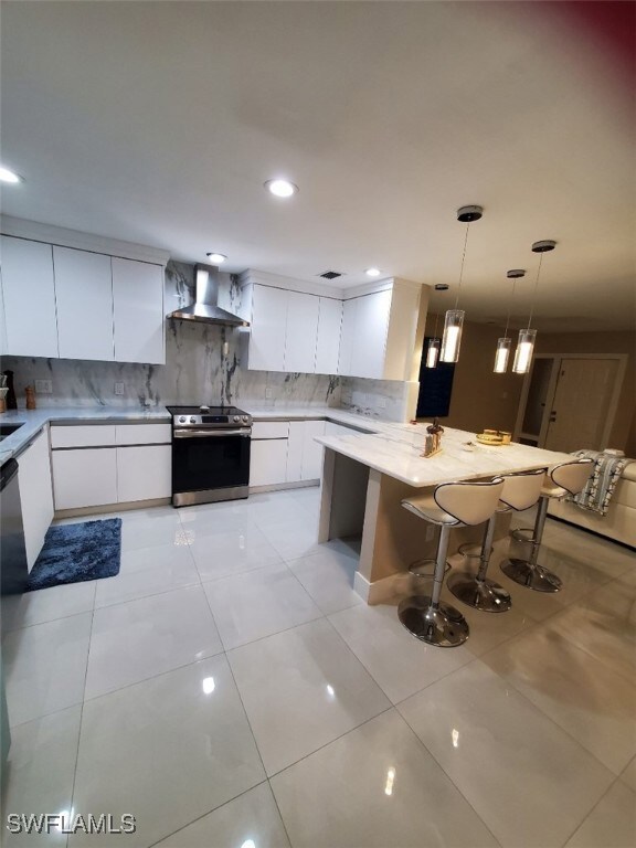Kitchen with wall chimney exhaust hood, a breakfas