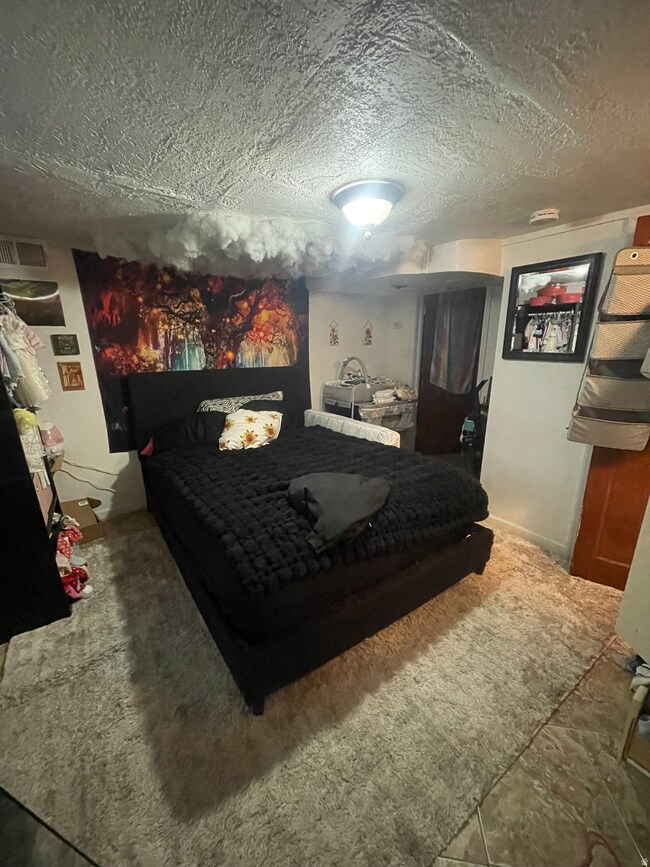 Carpeted bedroom with a textured ceiling