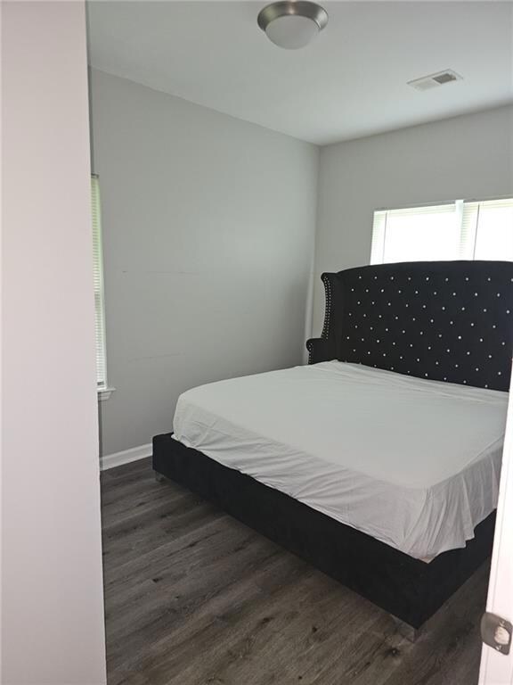 Bedroom with wood finished floors and baseboards