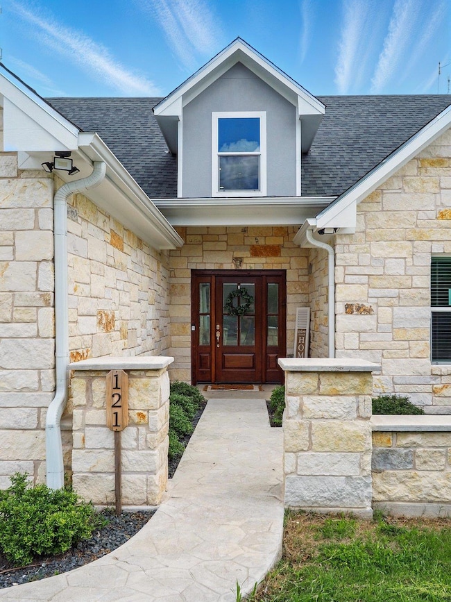 Property entrance with stone siding, a shingled r