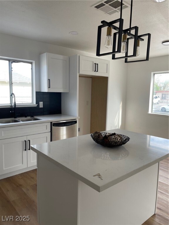Kitchen featuring a sink, a kitchen island, light