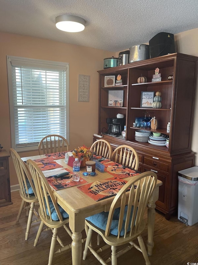 Dining space featuring light wood-style flooring and a textured ceiling