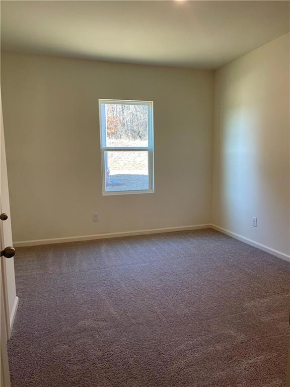 Spare room featuring baseboards and dark colored c